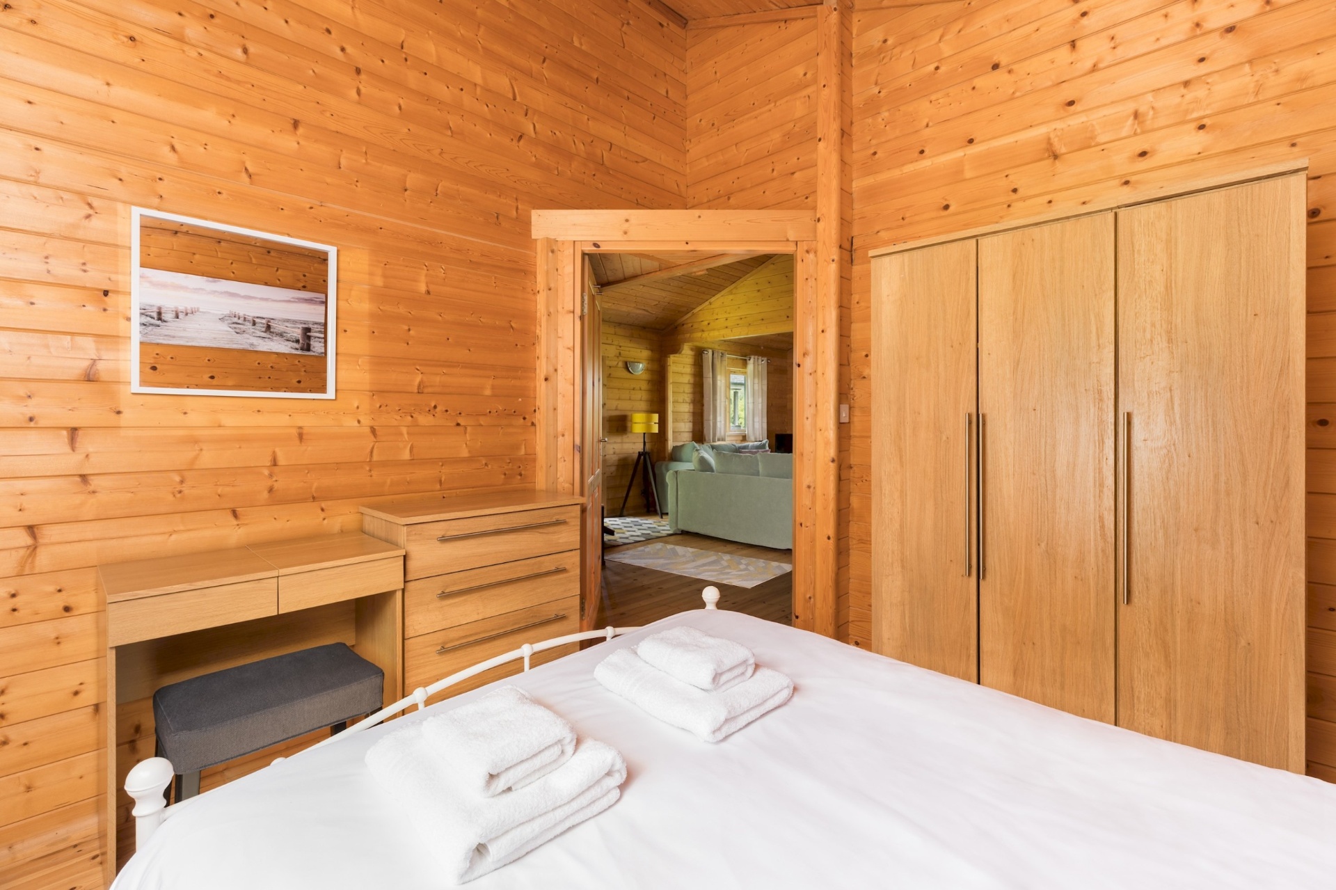Main bedroom dresser and wardrobe with view through to the lounge