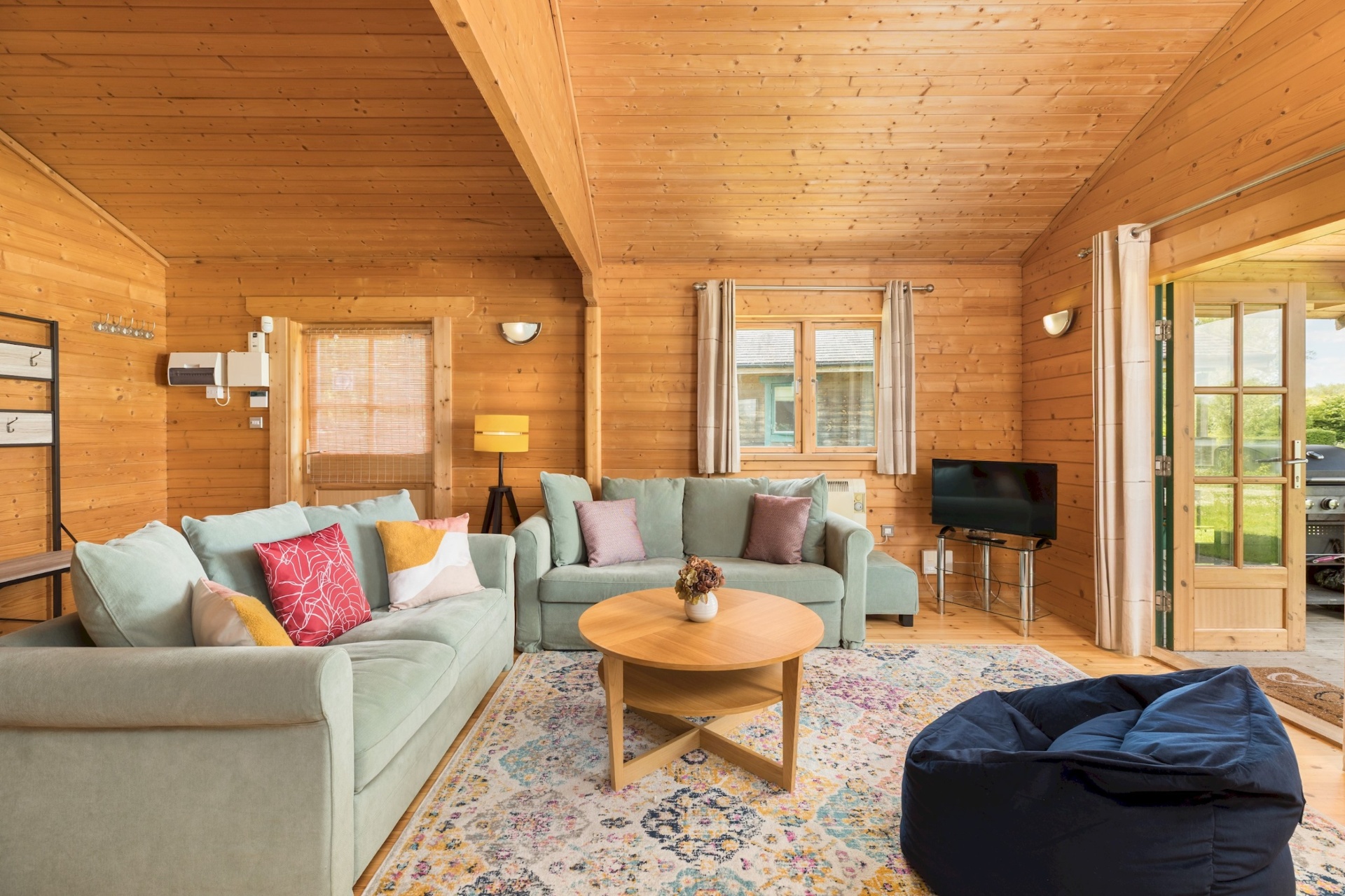 Lounge with two sofas, TV and beanbag at Primrose Lodge