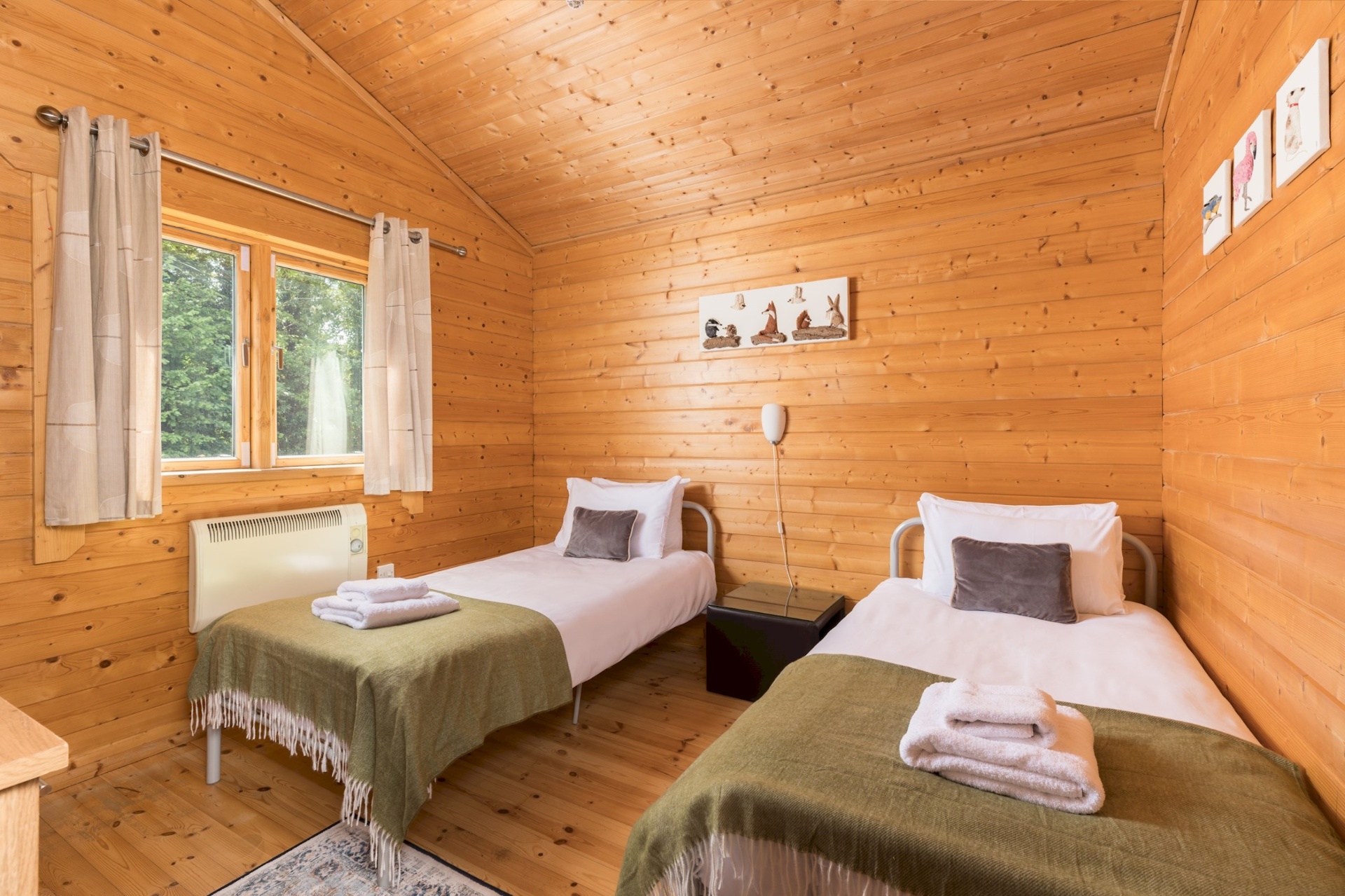 Twin bedroom at Primrose Lodge with two single beds and woodland artwork