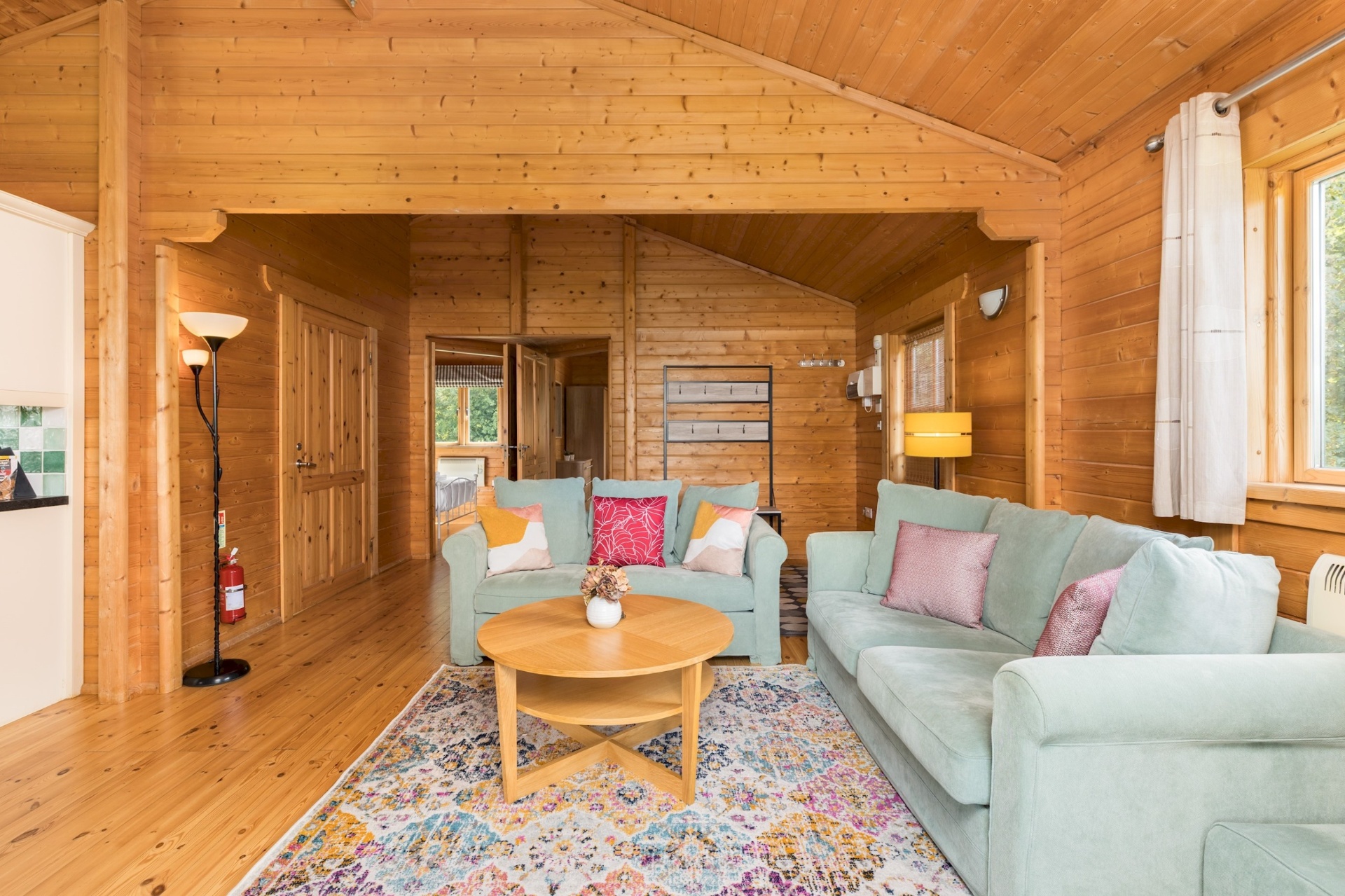 Sage-green sofas and patterned rug in the Primrose Lodge lounge